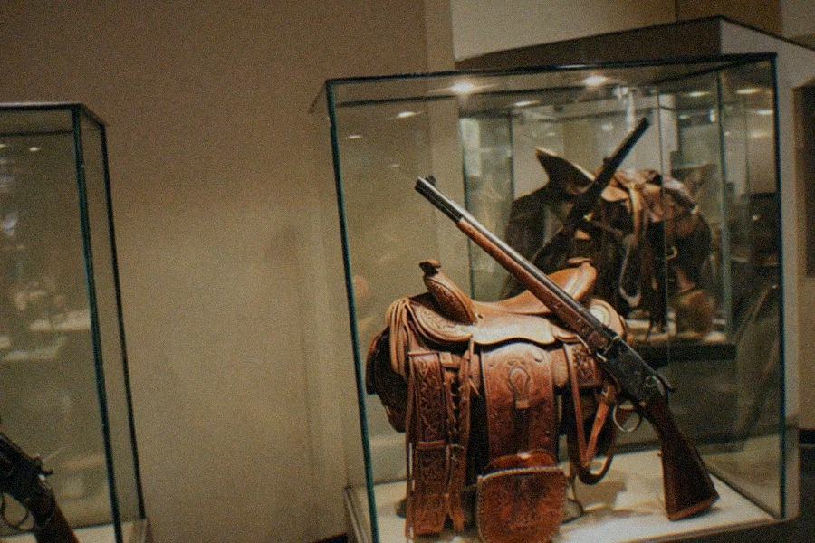 A historic stagecoach displayed in the Autry Museum of the American West galleries with Western landscape paintings on the wall behind it