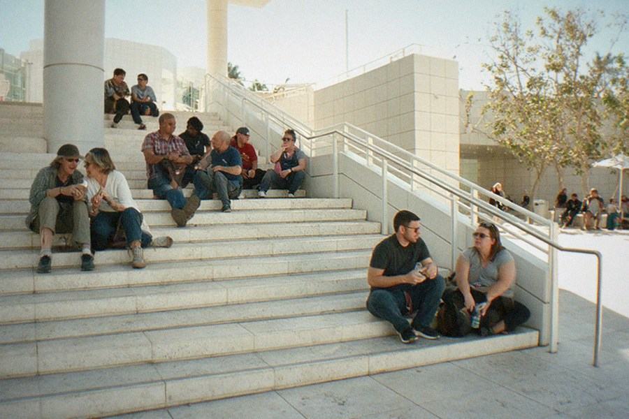 A guide gesturing toward a vintage automobile while a small group listens in a storage hall