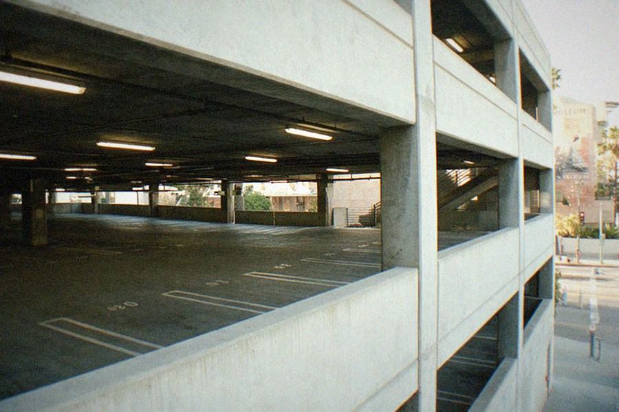 Museum parking structure with cars lined up and a garden staircase leading to an entrance.