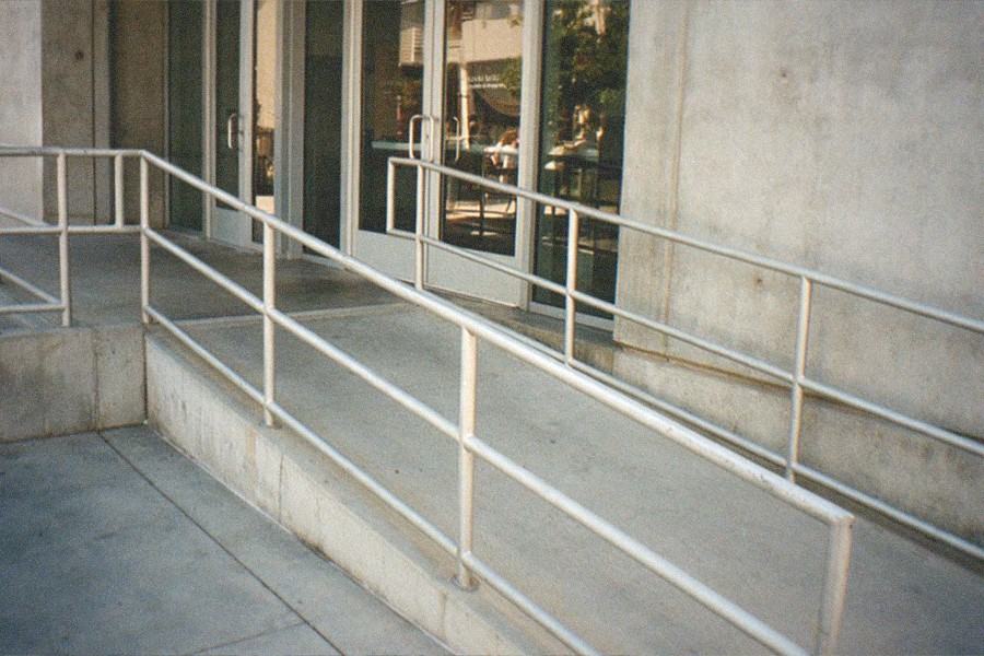 Museum entrance hall with ticket desk and tall windows onto a courtyard.
