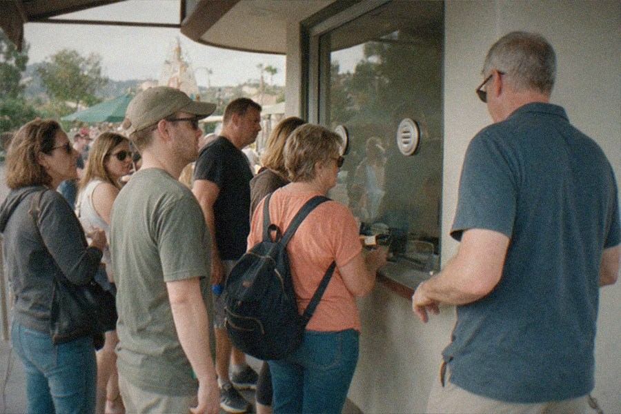 A museum ticket counter with a queue of visitors holding printed passes