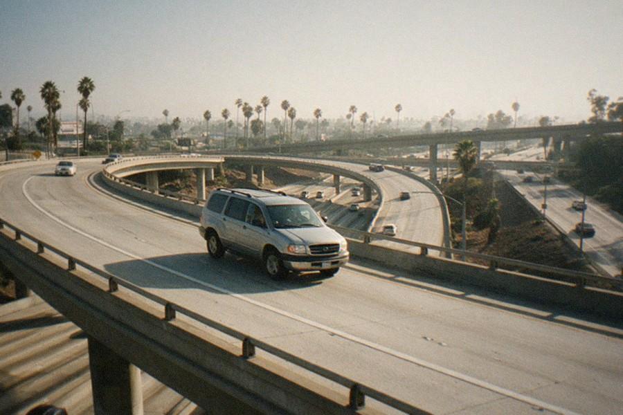 A Los Angeles freeway stretching toward distant hills in late afternoon light