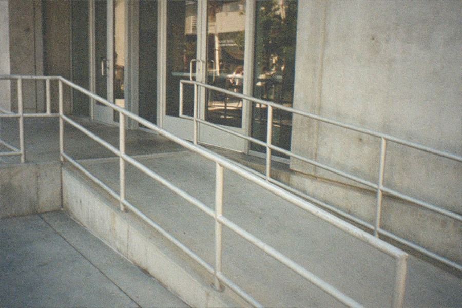 A row of restored street lamps standing in front of a modern museum building