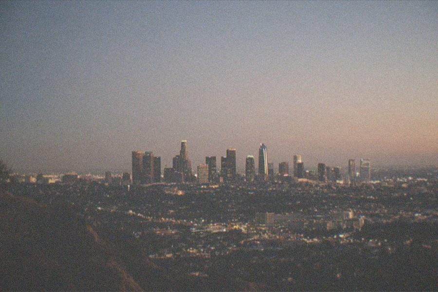 An observatory dome on a hillside above a city at dusk