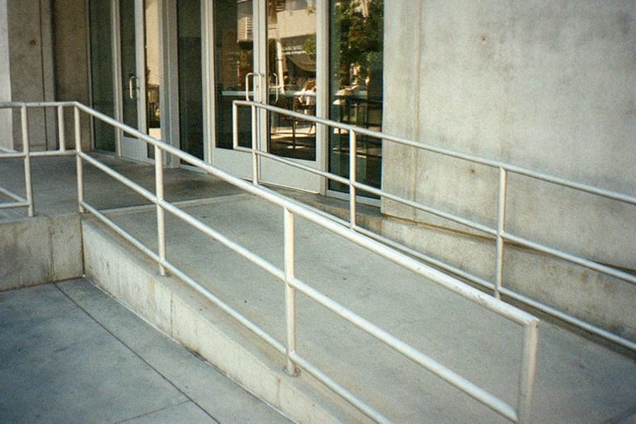 Empty museum plaza with locked glass doors and a closed sign on a weekday morning